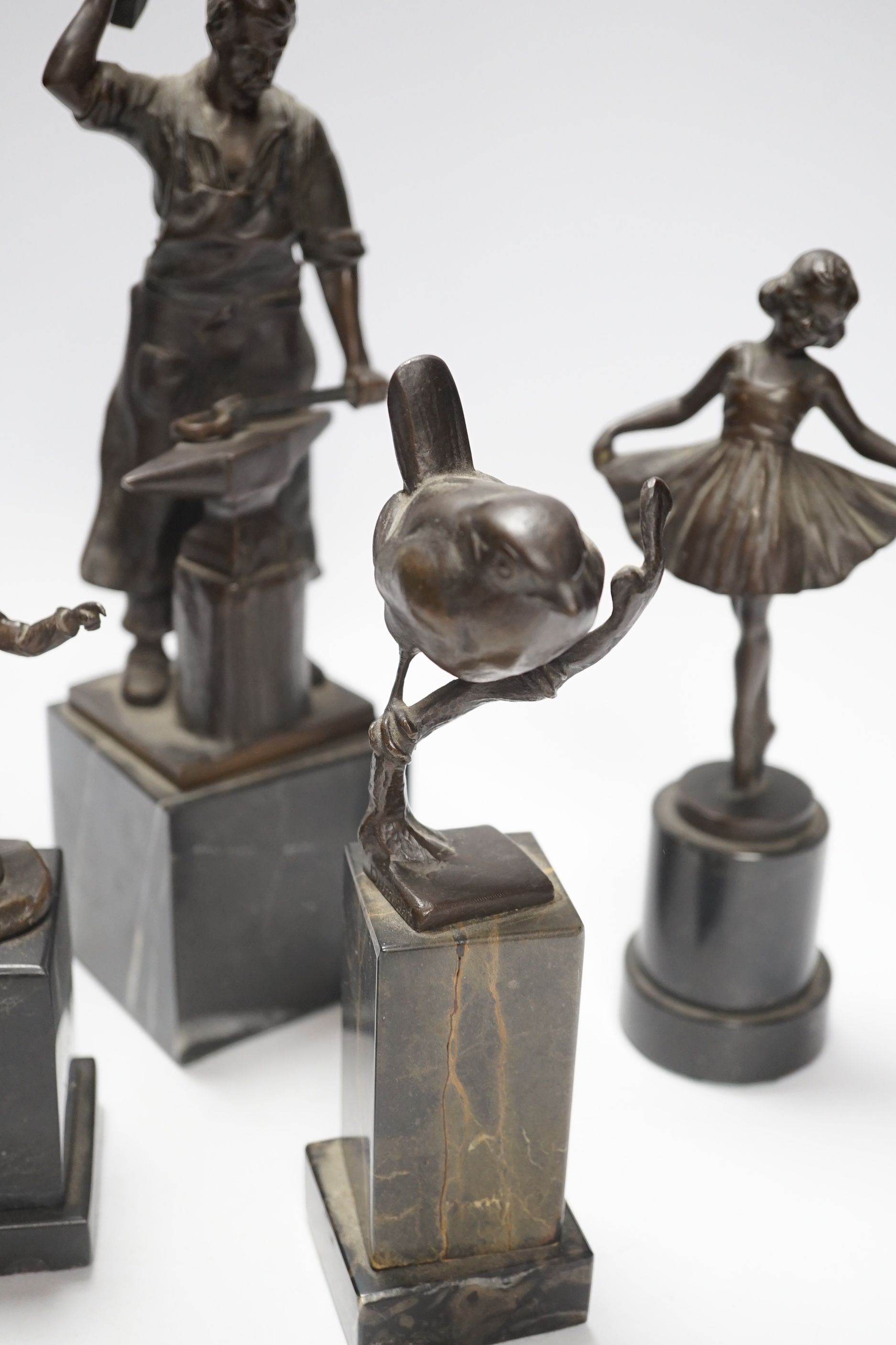 A German bronze of a blacksmith, indistinctly signed, a bronze figure group signed Öbold, a bronze of a Robin, signed K. Reynen and an unsigned bronze of a ballerina, all on marble bases, tallest 27cm (4)